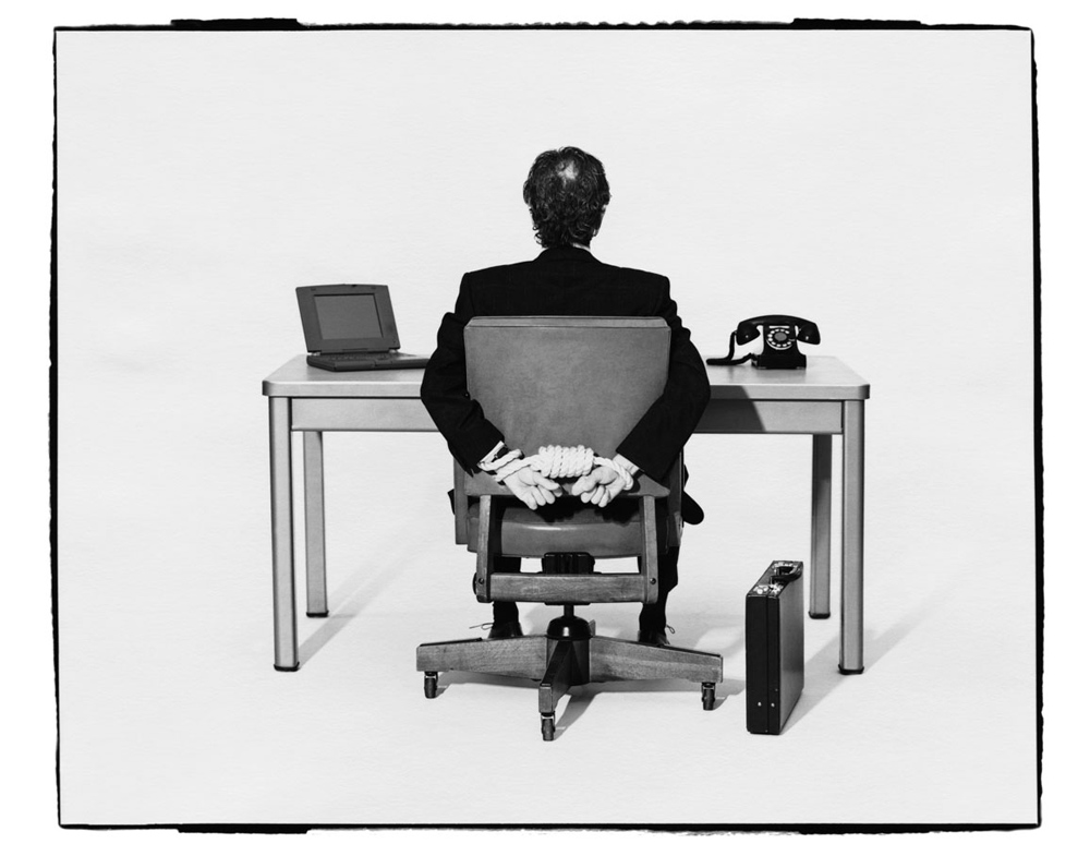 corporate-america-businessman-tied-to-desk_pop_13595